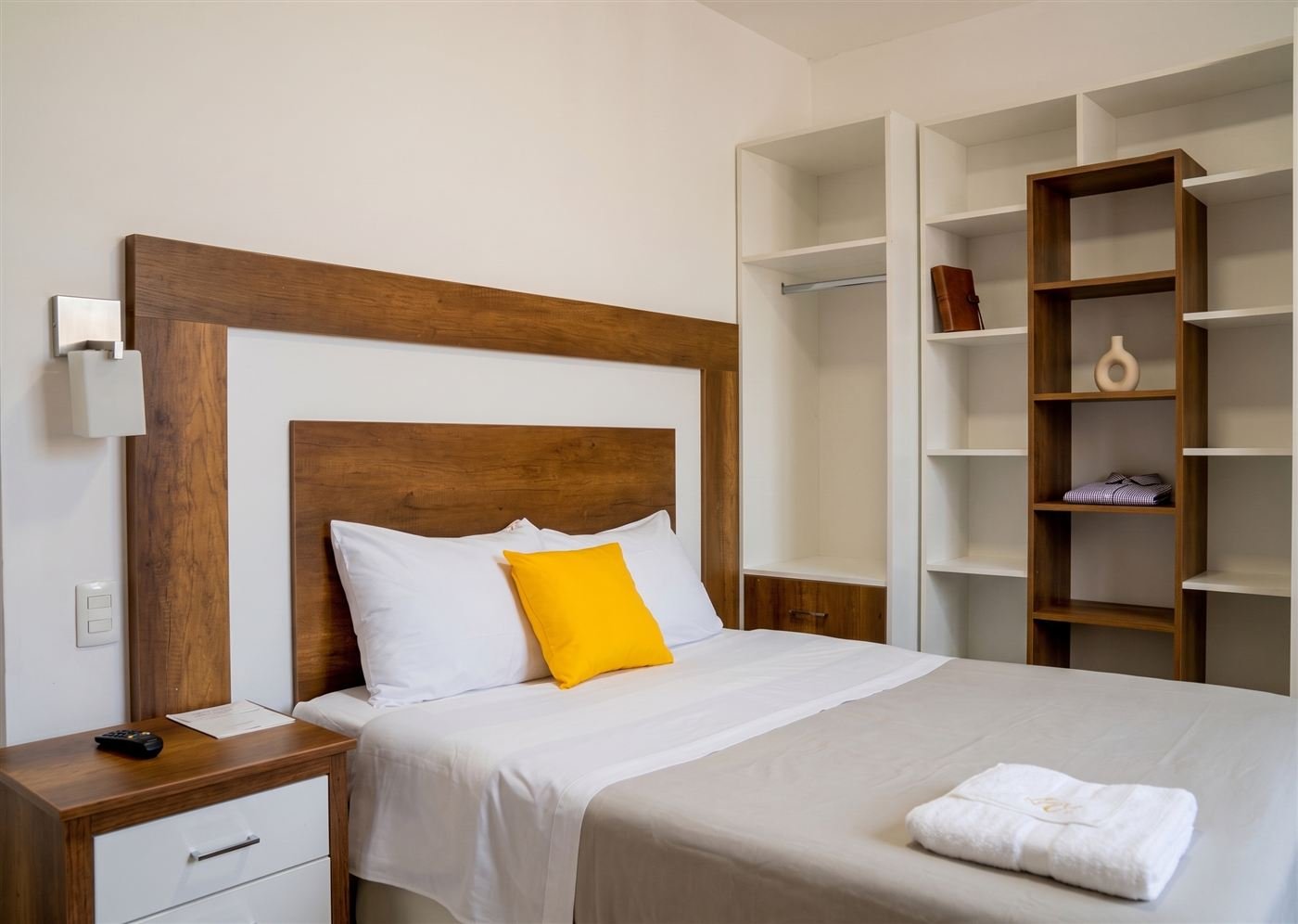 Habitación con cama matrimonial y estantería de madera